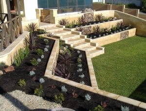 slopped backyard retainer wall with stairs and plants