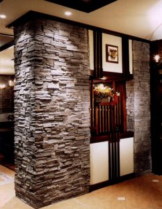 Ashburn Stone Veneer used inside home for feature wall next to bookshelf